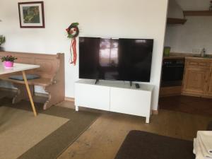 una sala de estar con una gran TV en un armario blanco en Ferienwohnung Christensen, en Murnau am Staffelsee