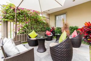 a patio with wicker chairs and colorful pillows at Tambo Dos de Mayo in Lima