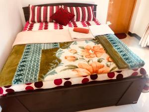 a bed with a floral quilt on top of it at Loversleap bungalow in Nuwara Eliya