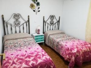 two beds sitting next to each other in a bedroom at Casas los Rosales in Guadix