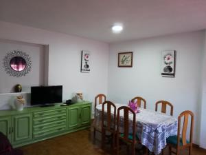 a dining room with a table with chairs and a television at Casas los Rosales in Guadix