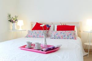 バルセロナにあるSpot Smart Nomadのベッドの上にトレイ(カップ2杯、花付)