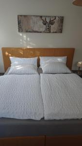 łóżko z białą pościelą i poduszkami w obiekcie Altenberger Stadtvilla w Dreźnie