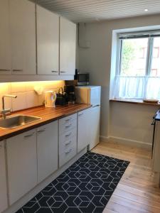 a kitchen with white cabinets and a sink and a window at TosleepinCPH in Copenhagen