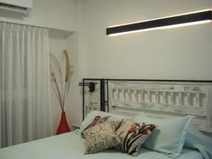 1 dormitorio con cama con almohadas y luz en Monoambiente BA Centro en Buenos Aires