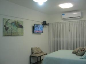 1 dormitorio con 1 cama, TV y silla en Monoambiente BA Centro en Buenos Aires