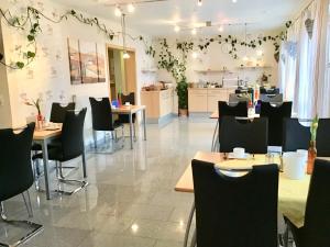 a restaurant with tables and chairs and a kitchen at Pension am Schlossberg in Reichenberg