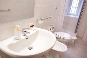 bagno bianco con lavandino e servizi igienici di MetròNapoli a Napoli