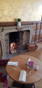 a living room with a fireplace and a wooden table at Schlosshotel Westerholt in Herten