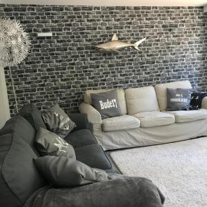 a living room with a couch and a brick wall at BUDE 17 in Timmendorfer Strand
