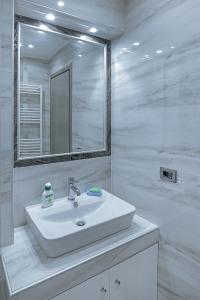 een witte badkamer met een wastafel en een spiegel bij Vila Dhimitri in Korçë