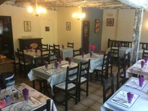 a dining room with tables and chairs with purple napkins at Auberge Henri IV in Ségur-le-Château