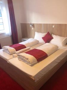 a large bed with three pillows on it at Hotel Oldesloer Hof in Bad Oldesloe