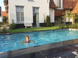 un niño pequeño nadando en una gran piscina en de Gasterie, en Koksijde