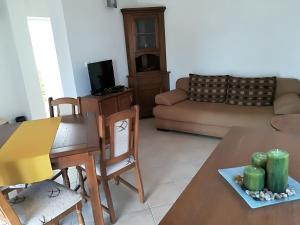 ein Wohnzimmer mit einem Tisch und einem Sofa in der Unterkunft Apartman Rosanda 1 in Premuda