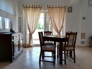 a dining room with a table and chairs and a window at Apartman Rosanda 1 in Premuda