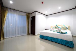 a bedroom with a bed and a large window at Baan Pattamaporn in Hua Hin