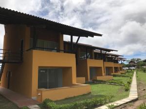 una gran casa amarilla con un patio verde en Winterville Gravatá - Flat 1012, en Gravatá