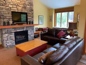 a living room with a couch and a fireplace at Pinnacle Ridge Condos by Fernie Central Reservations in Fernie