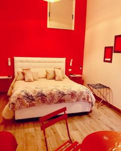 una camera con un letto con una parete rossa di Arianiello Suite a due passi dal Cristo Velato a Napoli