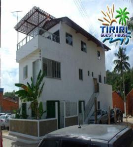 duży biały dom z samochodem zaparkowanym przed nim w obiekcie Pousada Tiriri Guesthouse w mieście Barra do Camaragibe
