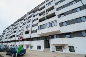 un bâtiment avec une voiture garée devant dans l'établissement Rezident militari, à Chiajna