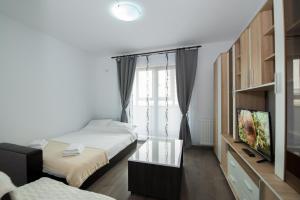 a bedroom with two beds and a flat screen tv at Rezident militari in Chiajna