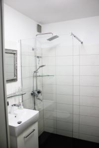 a bathroom with a glass shower and a sink at Ferienwohnung Stett in Meersburg