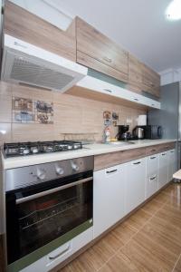 une cuisine avec des armoires blanches et un four à plaques de cuisson dans l'établissement Rezident militari, à Chiajna