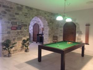 un tavolo da biliardo in una stanza con un muro in pietra di Agriturismo Paradiso 44 ad Assisi