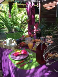 uma mesa de piquenique com comida e uma garrafa de sumo em Le Chalet dAZAE em La Rivière