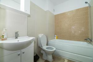 une salle de bain avec un lavabo, des toilettes et une baignoire dans l'établissement Rezident militari, à Chiajna 14 autres photos