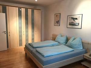 ein Schlafzimmer mit einem Bett mit blauen Kissen darauf in der Unterkunft Villa Theresa in Kaprun