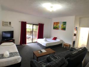 um quarto com uma sala de estar com uma cama e um sofá em Allan Cunningham Motel -Under New Management- em Toowoomba