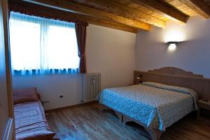 1 dormitorio con cama y ventana en Agritur Maso Pra' Cavai B&B en Balbido-rango