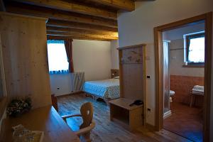 a room with a bedroom with a bed and a bathroom at Agritur Maso Pra' Cavai B&B in Balbido-rango