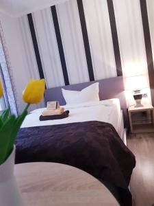 a bedroom with a bed with a black and white stripes at Hotel garni Morsum in Nordstrand