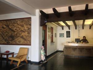 a woman and a child in a room with a counter at Hotel Del Parque in Guadalajara