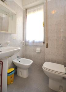 bagno con servizi igienici bianchi e lavandino di Condominio Aurora a Bibione