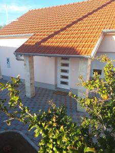 una casa con techo naranja y patio de ladrillo en Samodol en Drinovci