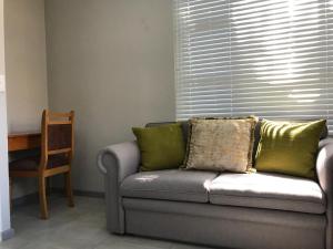 kanapa z zielonymi poduszkami w salonie w obiekcie 5 on Pieter Hugo w mieście Paarl