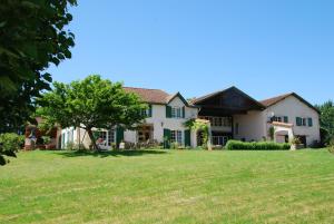 una casa con un gran patio con un árbol en Domaine Sainte Barthe, entre Marciac et Nogaro, en Aignan