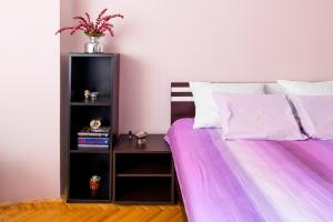 a bedroom with a bed with a night stand next to it at Apartment City center in Novi Sad