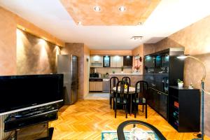 a kitchen and dining room with a television and a table at Apartment City center in Novi Sad