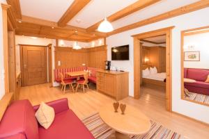 a living room with a red couch and a table at Das GÄSTEHAUS SCHNEIDER am Dorfplatz in Alpbach