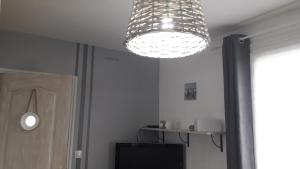 ein Kronleuchter, der von der Decke in einem Raum hängt in der Unterkunft chambre d'hôte - La ruche des Bleuets in Mulsanne