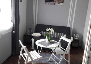 - un salon avec une table, des chaises et un canapé dans l'établissement chambre d'hôte - La ruche des Bleuets, à Mulsanne