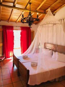 アルマカオ・デ・ペラにあるHotel de Charme Capela das Artesのベッドルーム(大型ベッド1台、蚊帳付)