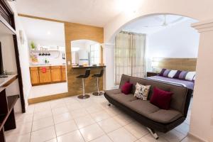 ein Schlafzimmer mit einem Bett und einem Sofa in einem Zimmer in der Unterkunft Quetzal Loft in Cancún