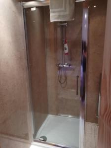 a shower with a glass door in a bathroom at Melrose in Fort William